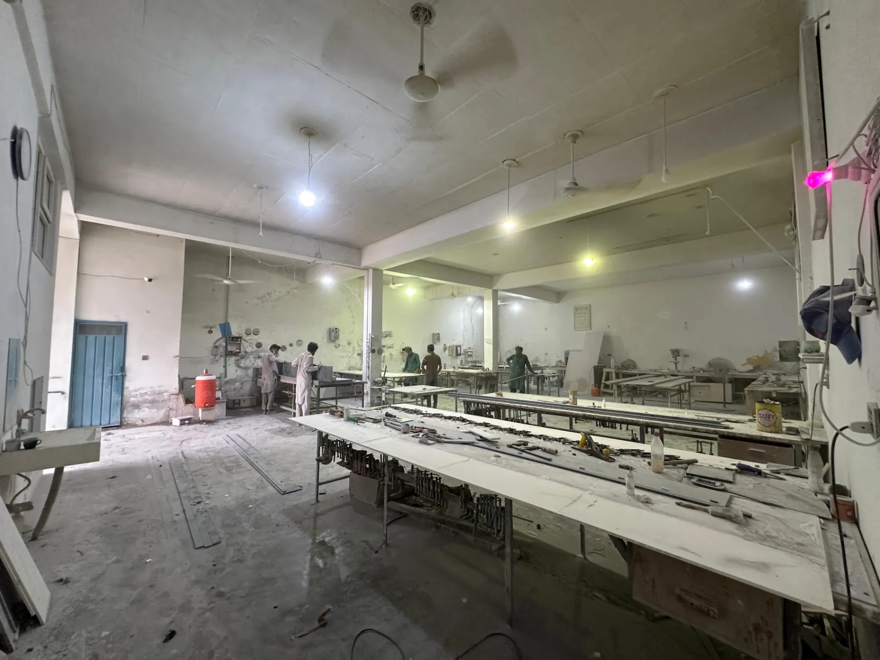 Wide view of the Lahore workshop with fabrication tables and tooling